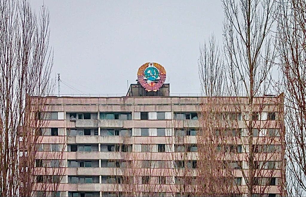 Герб СССР возвышается над крышами Припяти и виден издалека. (© Florian Wiedemann)