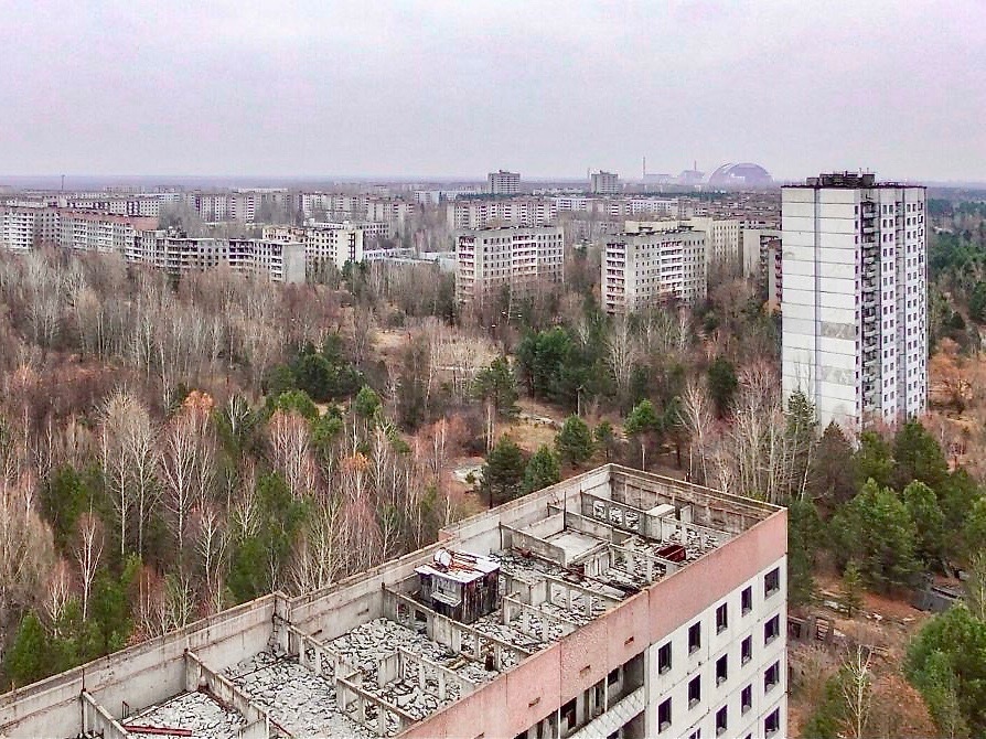 Вид на Припять. На заднем плане справа виден саркофаг четвертого реактора. (© Florian Wiedemann)