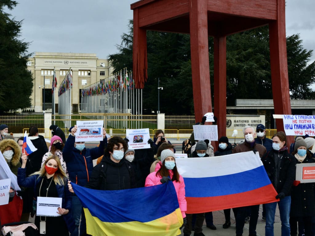 Люди пришли на женевскую площадь перед Дворцом Наций с флагами России, Беларуси, Украины. (© forall.swiss)